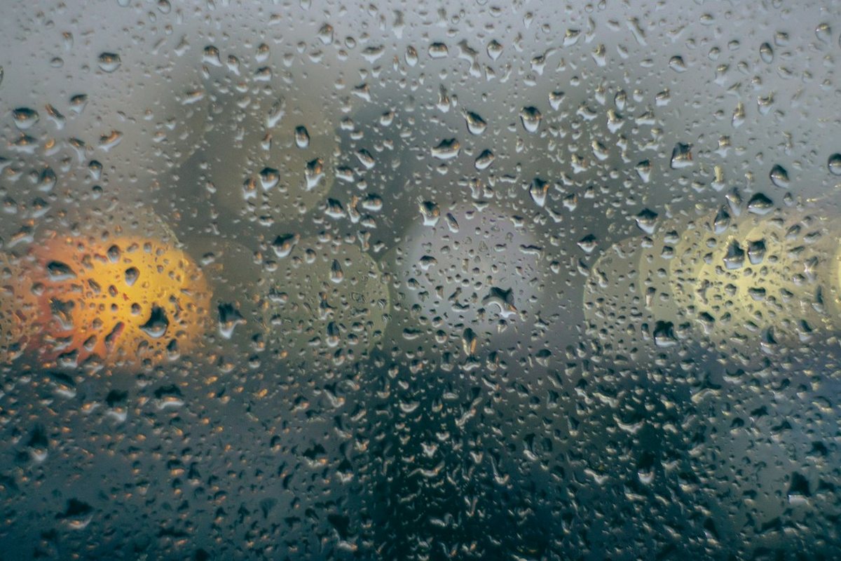 rain drops on a window with traffic lights in the background
