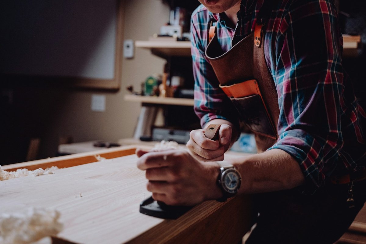 A carpenter working on a piece of wood
