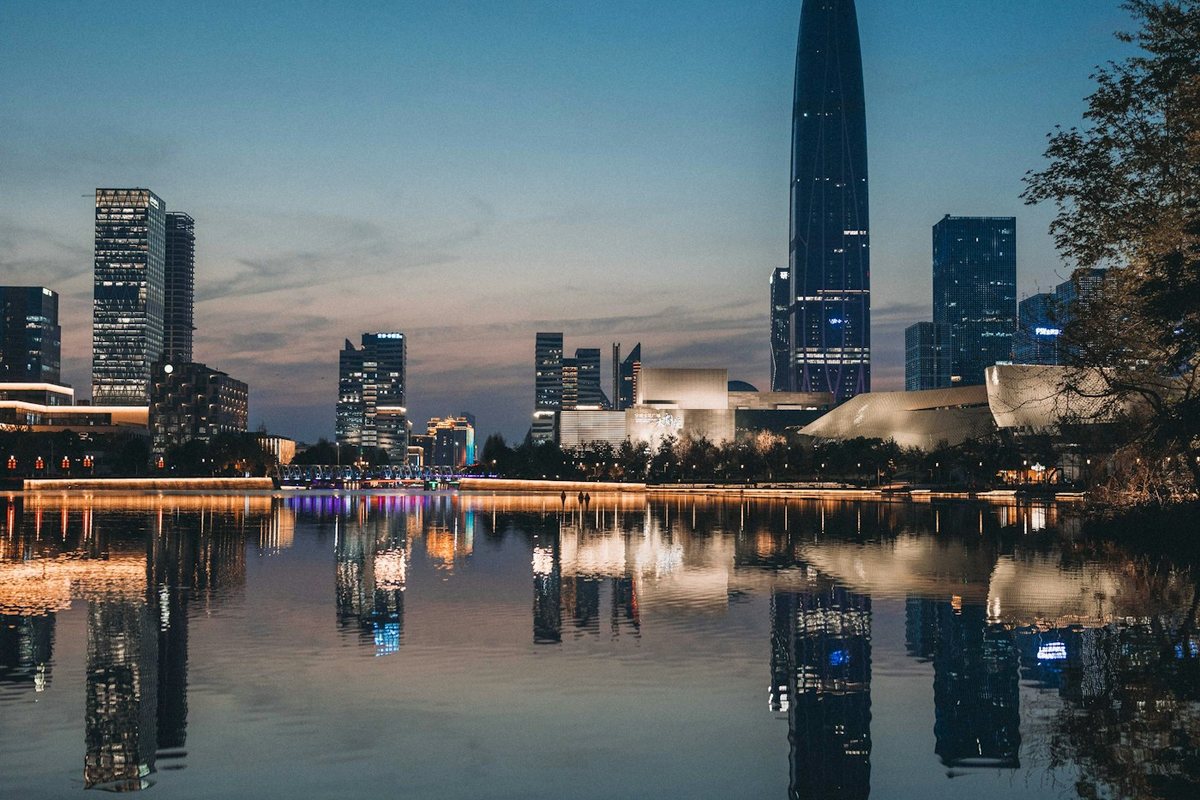 An illuminated city skyline reflected in calm water